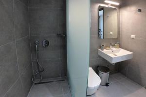 a bathroom with a sink and a toilet and a mirror at Sea View Apartment Grek Nea 3 in Nea Roda
