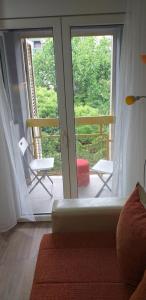sala de estar con una puerta corredera de cristal que da a un balcón en Apartman 4 - Studio Janja, en Soko Banja