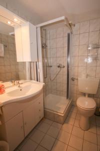 a bathroom with a sink and a shower and a toilet at Hotel Charlott in Eisenbach
