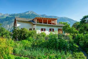 a house on a hill with mountains in the background at Zum Riesen Historic Refugium in Laces