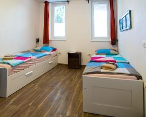 two beds in a room with two windows at Sobe Argo Izola in Izola