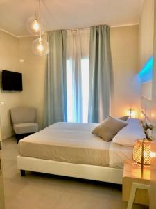 een slaapkamer met een groot bed en een raam bij ESMERALDA'S ROOMS in Porto San Paolo