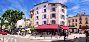 ヴァンスにあるLa Victoire Boutique Hotelの市通りに赤い日よけのある建物