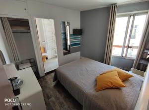 - une chambre avec un lit doté d'un oreiller jaune dans l'établissement Boutique Hôtel La Victoire - Vence centre, à Vence