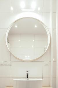 a bathroom with a sink and a large mirror at Hello Apartments RAI Rajska in Gdańsk