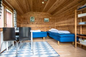 ブロメラにあるBromölla Camping o Vandrarhemのベッド2台、テーブル、椅子が備わる客室です。