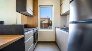 eine Küche mit einem Waschbecken und einem Fenster in der Unterkunft Lofos Village Chania in Agia Marina