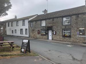 a building with a sign in front of a street at Masons Arms in Skipton