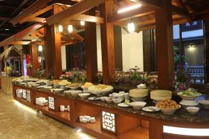 a buffet line with bowls and plates of food at Khách xá Bái Đính - Bai Dinh Guest House in Ninh Binh