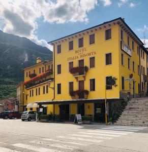 a yellow building on the side of a street at Italia Risorta in Arsiero