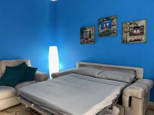 Habitación azul con cama y sofá en Relax in Taranto, en Taranto