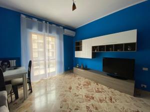 a blue living room with a television and a table at Relax in Taranto in Taranto