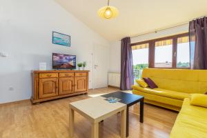 un soggiorno con divano giallo e tavolo di Apartments Josipovic a Fažana