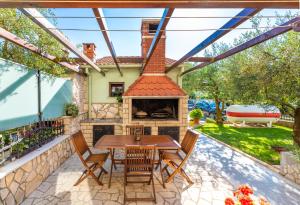 a patio with a table and a fireplace at Apartments Josipovic in Fažana