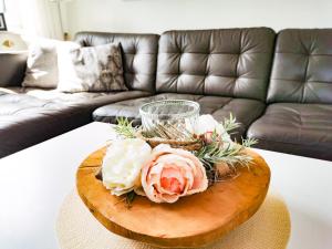 a coffee table with flowers on it in a living room at Ferienwohnung Auszeit Norddeich mit Seeblick I 5 Minuten zu Fuß zum Meer in Norddeich +15 photos