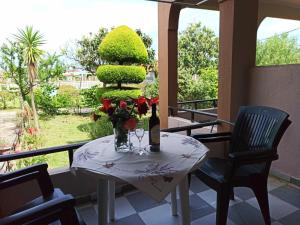 a table with a bottle of wine and flowers on a balcony at House Michalis in Sarti