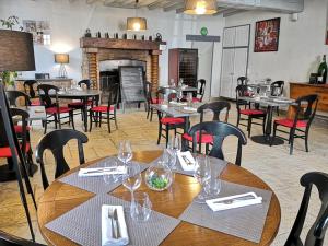 une salle à manger avec des tables, des chaises et une cheminée dans l'établissement Hostellerie du Val d'Or, à Mercurey