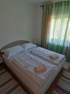 ein Bett mit zwei Kissen darauf in einem Schlafzimmer in der Unterkunft Apartman Juka in Krasno Polje