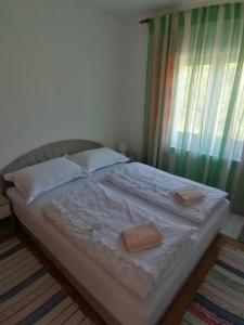 a bed with two pillows on it in a bedroom at Apartman Juka in Krasno Polje