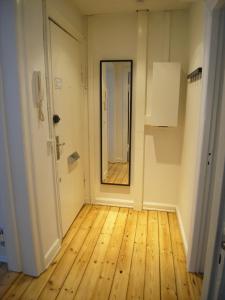een lege kamer met een houten vloer en een spiegel bij Ydunsgade in Kopenhagen