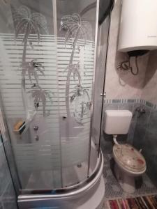 a bathroom with a shower with palm trees on the wall at Apartman Juka in Krasno Polje +18 photos