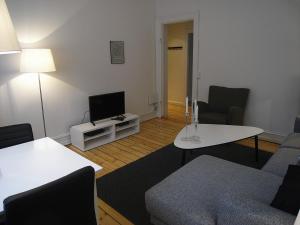 een woonkamer met een bank, een tafel en een tv bij Ydunsgade in Kopenhagen