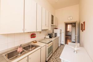 a kitchen with white cabinets and a sink at Casa Vacanze Cattolica in Cattolica +26 photos