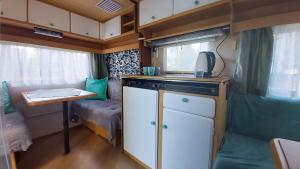 a small kitchen with a sink and a table in a caravan at Surf Przyczepa Jastarnia in Jastarnia