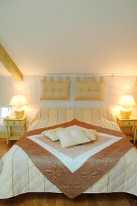 Manoir des Chanterelles في Meauzac: غرفة نوم بسرير كبير فيها مصباحين