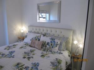 a bedroom with a bed with a floral comforter and a mirror at Fort House in Portsmouth