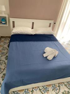 a blue bed with two white towels on it at La Corte del Re Borbone in Caserta