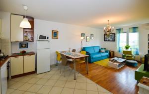 uma cozinha e sala de estar com uma mesa e um sofá azul em Lungo Mare em Pula