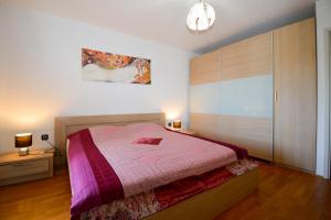 um quarto com uma cama com uma colcha rosa em Lungo Mare em Pula