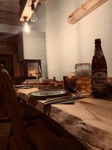 a wooden table with a bottle of beer and a fireplace at Wald WG - Haus am Wald in Warmensteinach