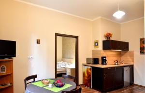 a kitchen and a dining room with a table and a room with a kitchen at Amelia Apartament Centrum in Gdańsk