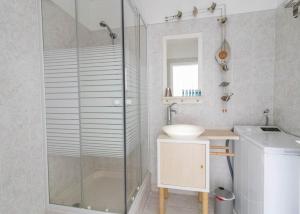 a bathroom with a glass shower and a sink at Les Mimosas in Roquebrune-Cap-Martin