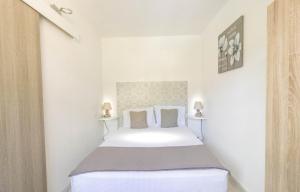 a bedroom with a bed with white sheets and pillows at Les Mimosas in Roquebrune-Cap-Martin