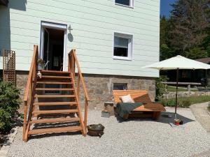 a stairway with a bench and an umbrella next to a house at Wald WG - Haus am Wald in Warmensteinach +3 photos