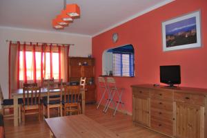 a kitchen and dining room with an orange wall at Aguileras in Alvor