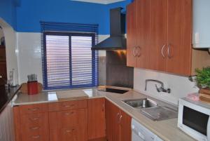 a kitchen with wooden cabinets and a sink at Aguileras in Alvor