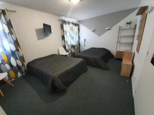 a small room with two beds and a tv at Hotel De La Poste in Espinasses