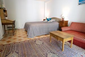 1 dormitorio con cama, sofá y mesa en Le 3 Rue Grande, en Moret-sur-Loing