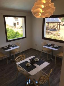 a dining room with tables and chairs and a chandelier at B&B Aly&Emy in Limpiddu