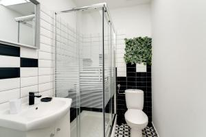 a bathroom with a toilet and a sink and a shower at Black & White Apartments in Rijeka