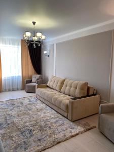 a living room with a large couch and a rug at 2-ухкомнатная современная новая квартира в центре города in Kostanay