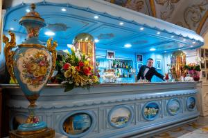 un bar avec un homme debout derrière un comptoir dans l'établissement Grand Hotel La Sonrisa, à SantʼAntonio Abate