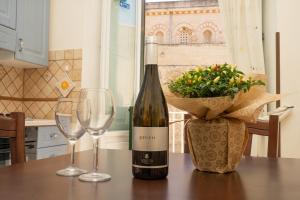 Una botella de vino y dos copas en una mesa. en Palazzo Tranfo Al Duomo Accommodation, en Tropea
