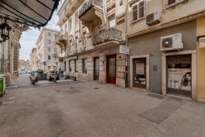 an empty street in a city with buildings at Black & White Apartments in Rijeka