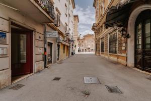 an empty street in a city with buildings at Black & White Apartments in Rijeka