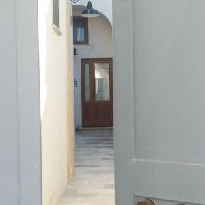 un pasillo con una puerta marrón y un piso con un pasillo en Margy House, en Morciano di Leuca